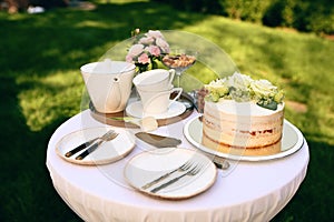Table setting, ceramic teapot, teacups, cake