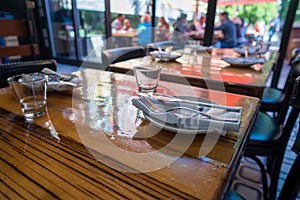 Table setting of cups, napkins, plates, and utensils in casual restaurant