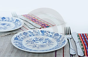 Table setting for dinner: a plate, a fork, a knife on a woven cloth napkin with an embroidered pattern,  traditional handmade in