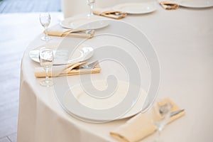 Table setting element empty plates with cutlery on white tablecloth