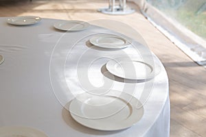Table setting element empty plates with cutlery on white tablecloth