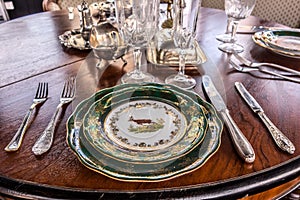 Table setting. In the foreground plate, fork, spoon, knife closeup