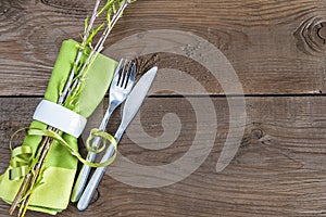 Table setting with green napkin with ring, willow twigs