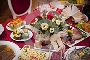 Table setting for a holiday, with red flowers