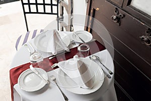 Table setting for a lovey dinner. Empty glasses set in restaurant. Part of interior. napkins, plates, and cutlery.