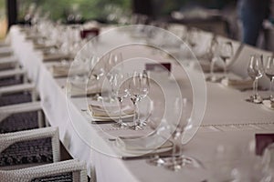 Table setting for a party or wedding reception in a restaurant. Row of ladder-back chairs set