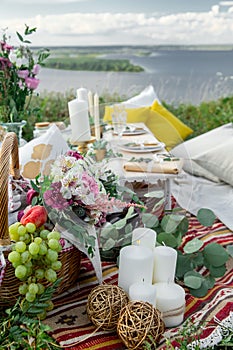 Decorated elegant wooden table in rustic style with eucalyptus and flowers, porcelain plates, glasses, napkins and cutlery