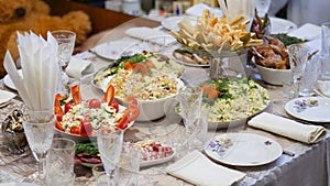 Table setting. Plates with snacks are beautifully placed on the festive home table. Dinner dishes and glasses are placed