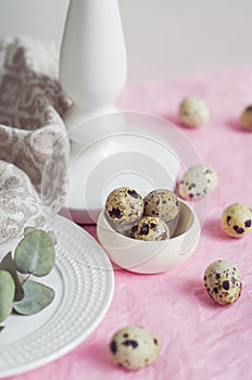 Table setting with quail eggs, white plate, green twig