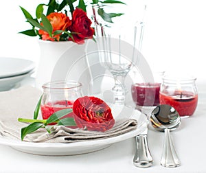 Table setting with red buttercup flowers