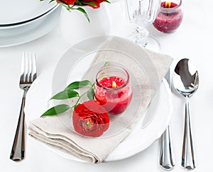 Table setting with red buttercup flowers