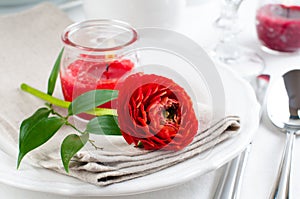 Table setting with red buttercup flowers