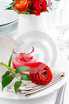 Table setting with red buttercup flowers