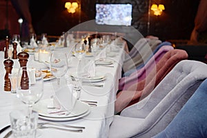 Table setting with sparkling wineglasses, plates with white napkins and cutlery on table, copy space.