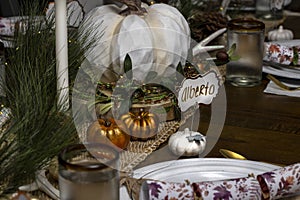 Table setting for a Thankgiving Dinner with pumpkin decorations and nametags
