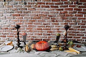 Table setting for Thanksgiving day. Autumn table with pumpkins and candles. fall home decoration for festive dinner