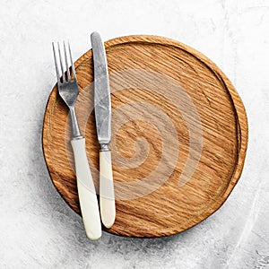 Table setting with vintage cutlery and wooden plate