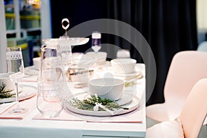Table setting in white color, with decoration of green. Table setting for event party or wedding. Decor in green and
