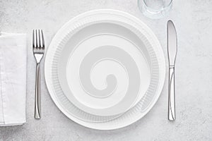 Table setting with white plates, glass, napkin, fork and knife