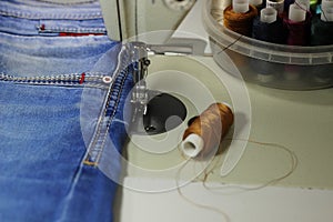 On the table of the sewing machine lie denim fabrics, close-up,