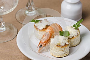 Table with a small plate with a cooked prawn. photo