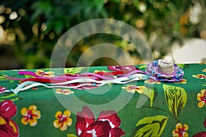 On the table a small straw hat with colored ribbons