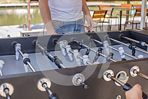 Table soccer. Foosball in a childrens playroom. Close-up during the game. Soccer table kids home toys, football family game table