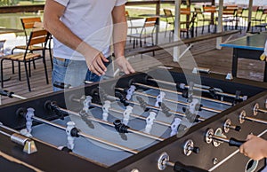 Table soccer. Foosball in a childrens playroom. Close-up during the game. Soccer table kids home toys, football family game table