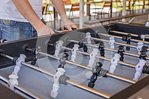 Table soccer. Foosball in a childrens playroom. Close-up during the game. Soccer table kids home toys, football family game table