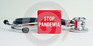 On the table is a stethoscope and a red cube with the inscription - STOP PANDEMIA