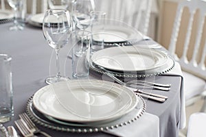 a table with a tablecloth, beautiful serving of white dishes, a beautiful plate, dinner in a restaurant