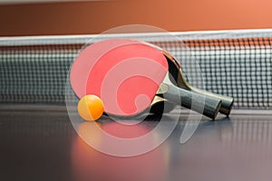 Table tennis racket with ball on black table