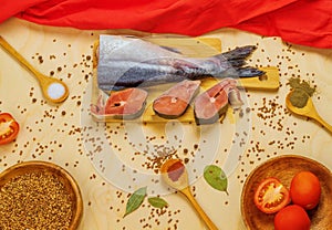 On the table there is a red fish called pink salmon, as well as buckwheat, red tomatoes