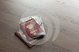 On the table there is a Russian passport inside various dollar bills and small change. finance