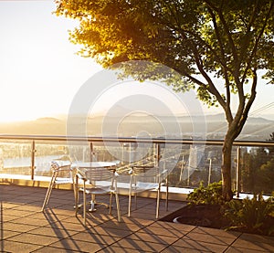 Table with three chairs with beuatiful view on Portland during sunrise