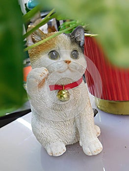 A table top beckoning cat claywork doll on display