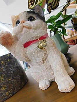 A table top beckoning cat claywork doll on display