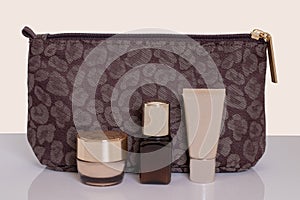 Table top on cosmetic background. Close-up of a beautiful brown cosmetic bag with various acial care products on a bright table