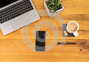 Table Top desk view with pencil a plant, coffee, workspace, mobile display and laptop