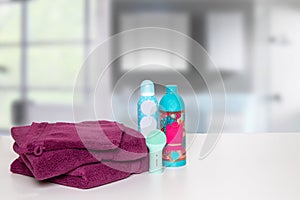 Table top on towels background. Closeup of fresh soft terry bath towels with soap and shampoo bottle on table over blurred