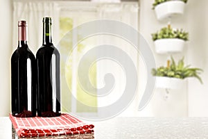 Table top with two wine bottles and space for products with nice bright home interior.