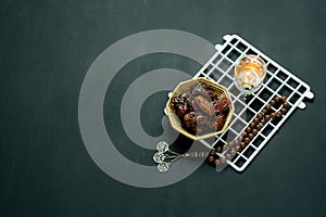 Table top view aerial image of decorations Ramadan Kareem holiday background.Flat lay arrangement dates with brown rosary &