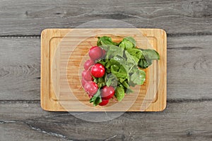 Table top view, bunch of fresh wet radish Raphanus with green