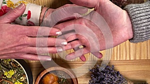 Table top view female male hands while divination palmistry session