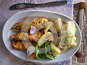 TABLE top View.A plate of Haddock Fillets with Potato, Green Bell Pepper and Garlic Sauce Dip,