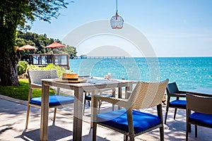 Table in tropical restaurant and beach with turquoise water