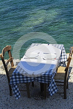 Table and two chairs of street greece restaurant on Crete in the sunny day