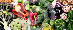 Table with vegetables on a light wood background. Pepper, cabbage, broccoli, radish, garlic. Healthy eating concept