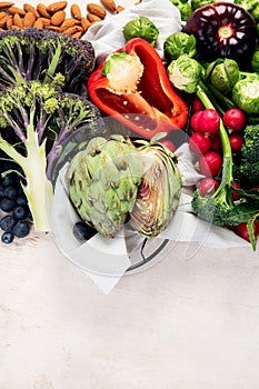 Table with vegetables on a light wood background. Pepper, cabbage, broccoli, radish, garlic. Healthy eating concept