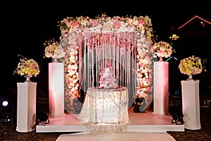 Table with a wedding cake, candles, light and flowers. wedding decoration